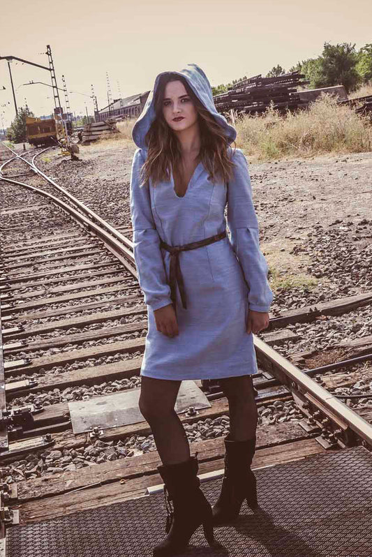 Vestido azul claro de manga larga, con escote en uve y capucha.