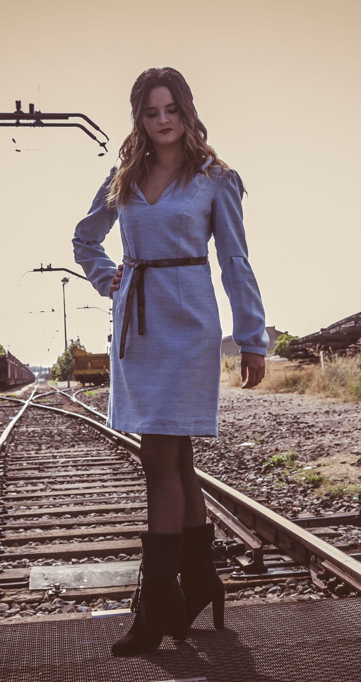 Vestido azul claro de manga larga, con escote en uve y capucha. 