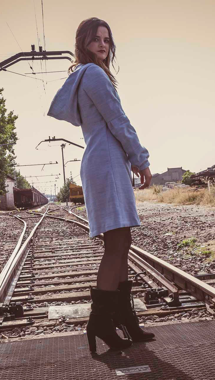 Vestido azul claro de manga larga, con escote en uve y capucha. 