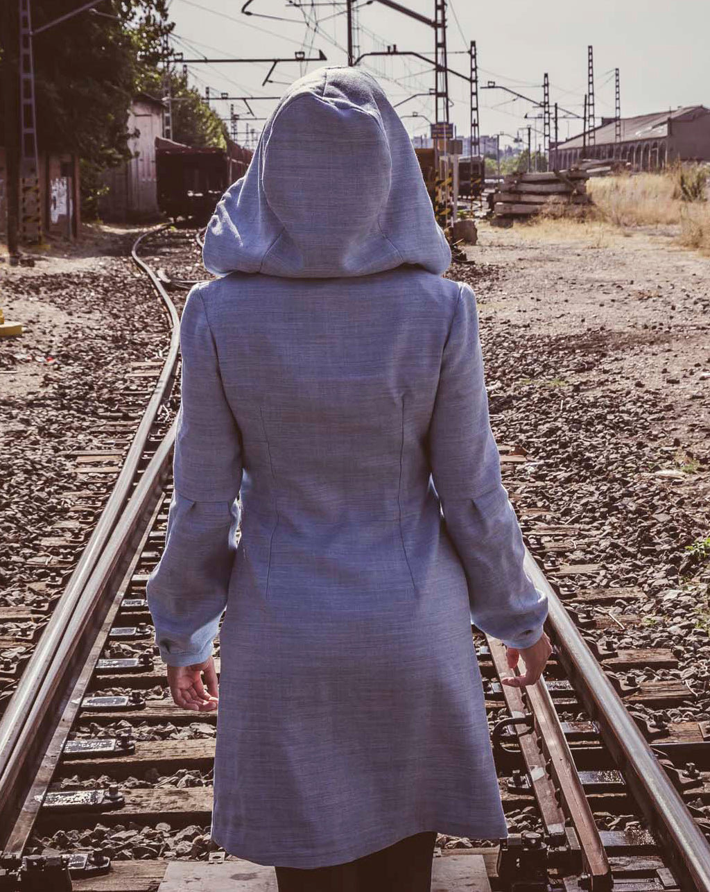 Vestido azul claro de manga larga, con escote en uve y capucha. 