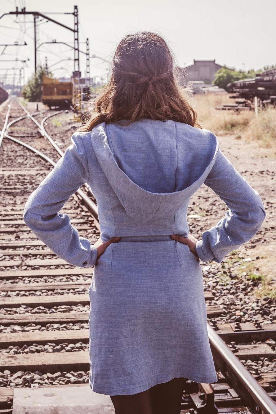 Vestido azul claro de manga larga, con escote en uve y capucha. 