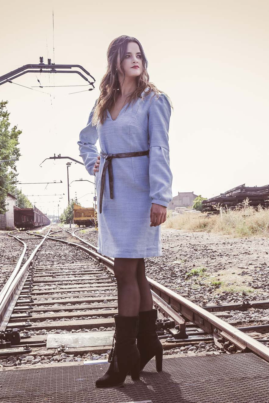 Vestido azul claro de manga larga, con escote en uve y capucha. 